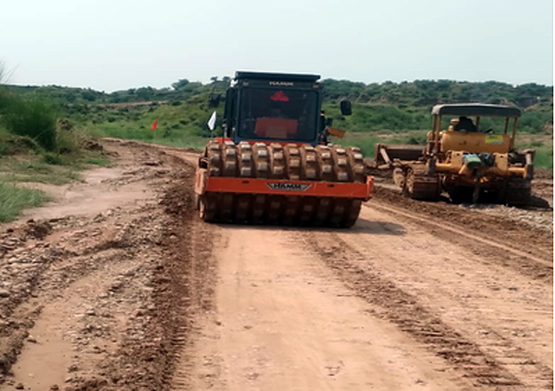 Rollers compacting the 208-ft road formation, Blue World City