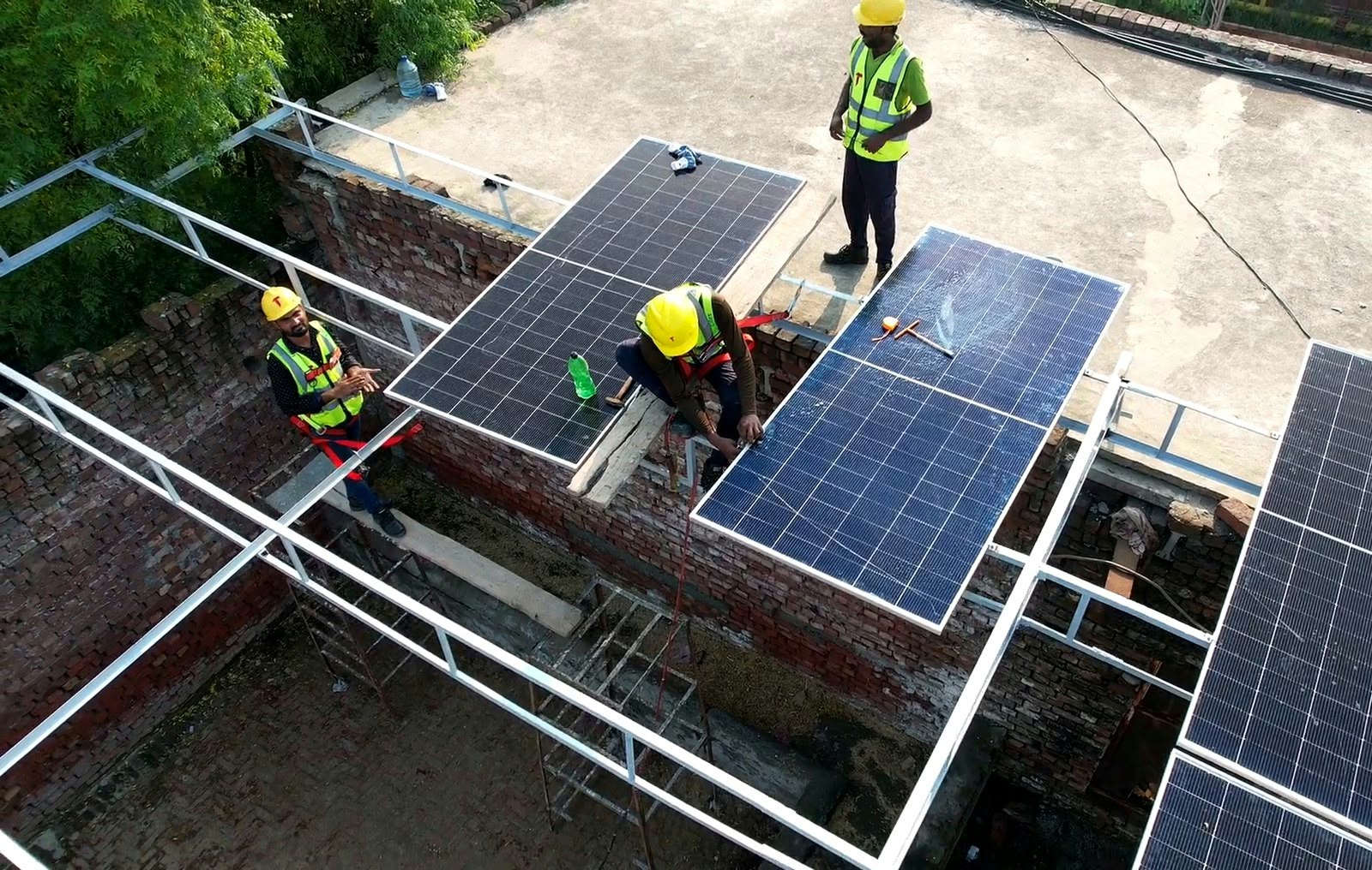 Tekton Engineering crew fitting panels on the raised steel frame of a 350 kW factory rooftop solar PV system